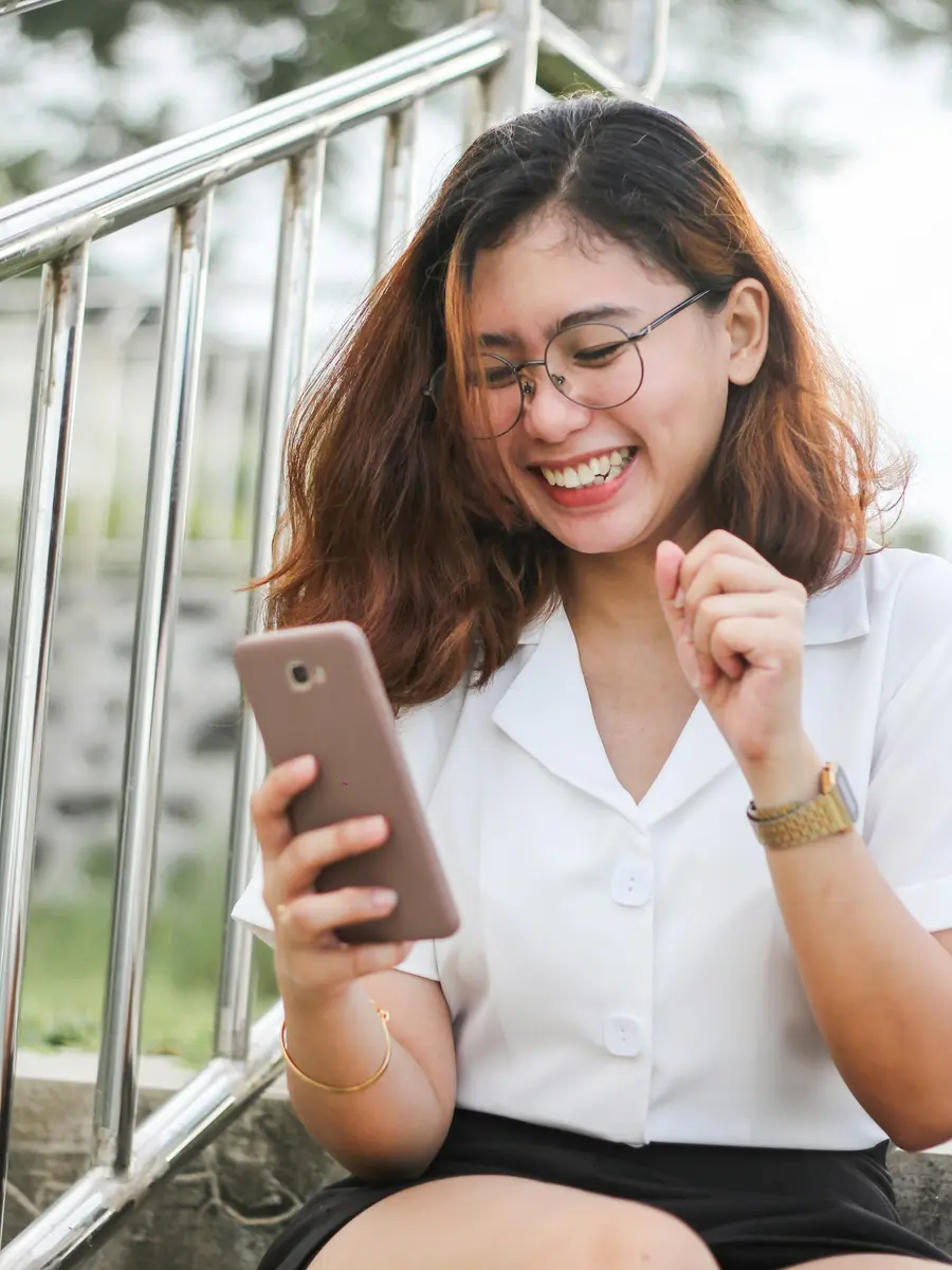 Compradora sonriendo al leer la respuesta en su celular