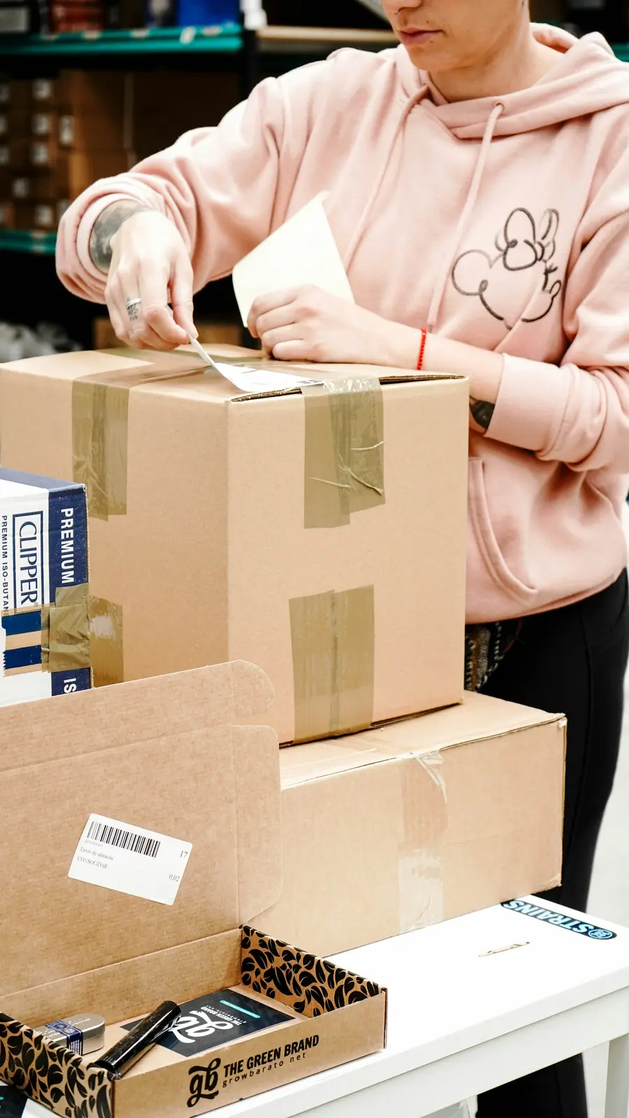 Persona sellando una caja con cinta para despachar un pedido